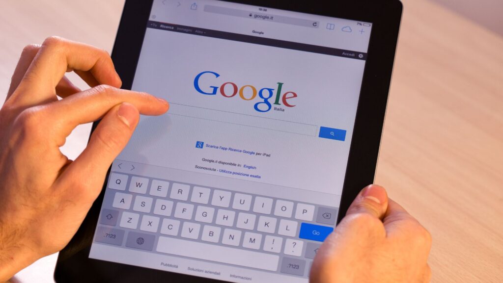 Pessoa segurando o tablet e pesquisando no Google para demonstrar como funciona o Marketing Contábil